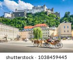 Beautiful panoramic view of the historic city of Salzburg with traditonal horse-drawn Fiaker carriage and famous Hohensalzburg Fortress on a hill on a sunny day with blue sky and clouds in summer