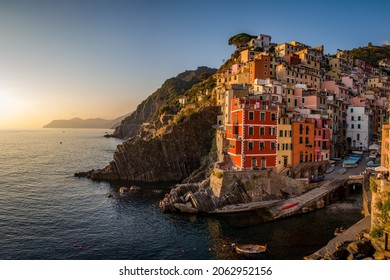 The beautiful panoramic view of Riomaggiore bathed in the sun at summer sunset, Liguria, La Spezia, Italy  (Mediterranean Sea), Europe. Awesome background with blue sky HD. Perfect Wallpaper 4k.