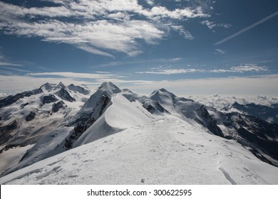 Beautiful panoramic view of summer landscape around Breithorn in Pennine Alps with cloudy blue sky.
