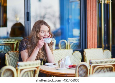 Beautiful Parisian woman in cafe, drinking coffee and eating macaroons, traditional French dessert - Powered by Shutterstock