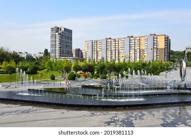 A beautiful park with fountains and trees against of tall houses, buildings and skyscrapers. Drone view, cityscape. Spring, summer street in city Dnipro, Dnepropetrovsk, Ukraine, 2021-07-01
