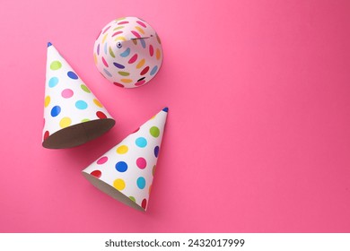 Beautiful party hats on pink background, top view. Space for text