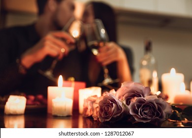 Beautiful passionate couple having a romantic candlelight dinner at home, drinking wine, toasting - Shutterstock ID 1287012067