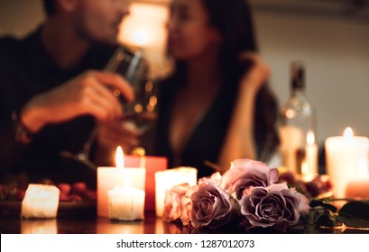 Beautiful Passionate Couple Having A Romantic Candlelight Dinner At Home, Drinking Wine, Toasting