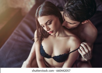 美しい情熱的な夫婦がベッドでセックスをしている。