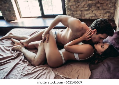 Beautiful passionate couple is having sex on bed.