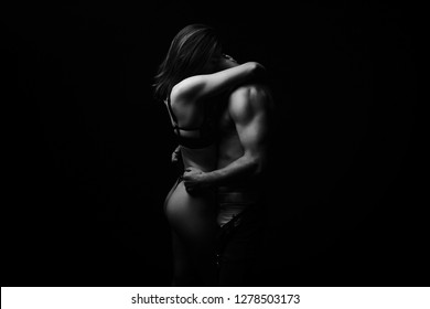 Beautiful passionate  couple hugging couple on black background, black and white