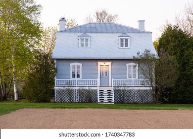 Beautiful patrimonial grey wooden country house with silver metal Mansard roof and dormer windows in Ste-Famille, Island of Orleans, Quebec, Canada