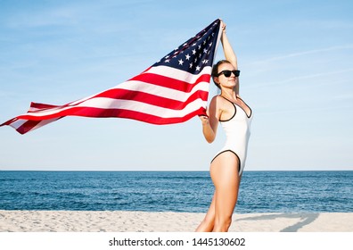 Beautiful patriotic woman holding an American flag on the beach.  USA Independence day, 4th July. Freedom concept - Powered by Shutterstock