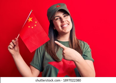 Beautiful Patriotic Woman Wearing T-shirt With Red Star Communist Symbol Holding China Flag Smiling Happy Pointing With Hand And Finger