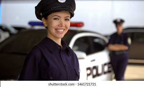 Beautiful patrolwoman smiling near police car, police academy advertisement