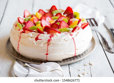 Beautiful Pavlova cake dessert with meringue and fresh fruit on white background
