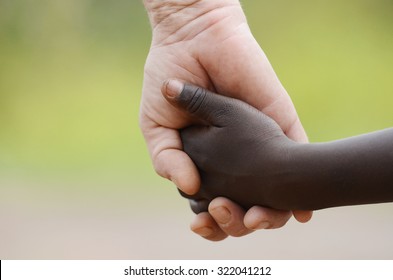 Beautiful Peace Symbol - White Woman Black Child Holding Hands. African Peace Symbol. White woman holds hands with a little native African girl, in Bamako, Mali. 