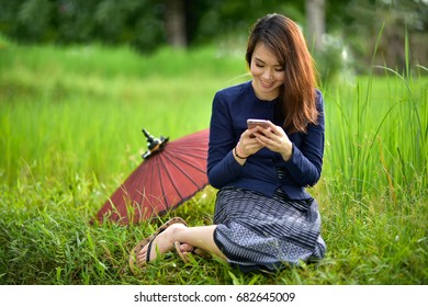 Beautiful Peasant Women Are Using Smartphones On Traditional Thai Culture.