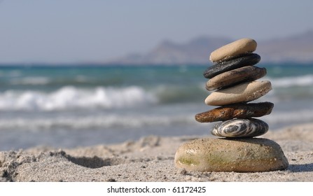 beautiful pebble stack on a sandy beach (sea on the background)