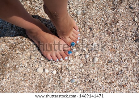 Beautiful pedicure on the sea sand. Blue, summer pedicure. Relax on the beach.