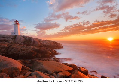 Beautiful Peggy Cove Light House with Sunset, Nova Scotia, Canada. Photo shows tourists watching sunset. - Powered by Shutterstock