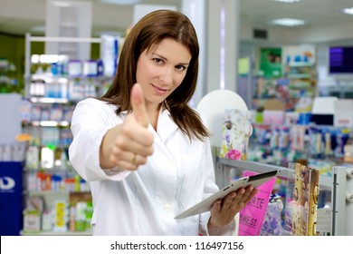 Beautiful Pharmacist Working In Pharmacy With Ipad Thumb Up