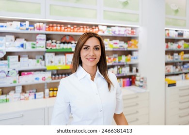 Beautiful pharmacist working and standing in a drug store and doing a stock take. Portrait of a positive healthcare worker or a chemist at his work. She is standing and looking at camera. - Powered by Shutterstock