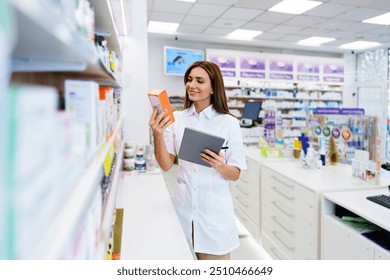 Beautiful pharmacist working and standing in a drug store and doing a stock take. Portrait of a positive healthcare worker or a chemist at his work. - Powered by Shutterstock