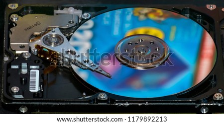 Beautiful photo of inside of harddisk, as symbol of computer storage. Showing harddisk's colorful platter and harddisk head on the top of the platter, captured from the side.