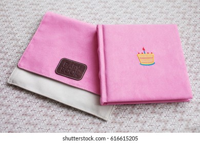 Beautiful Photobook In Light Pink Textile Cover With Textile Box. Baby Photobook With Decorative Embroidery Of Birthday Cake.   Low Depth Of Sharpness