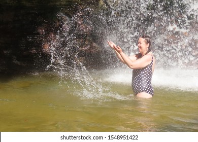Beautiful photographed woman taking a bath in Pedra Furada waterfall in Presidente Figueiredo with a very big expression of happiness