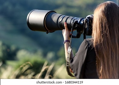beautiful photographer with professional camera and very long optics