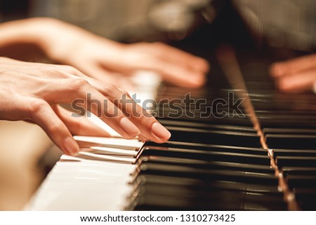 Beautiful Piano Melody...Close up view of female hands playing on piano her favorite classical music. Musical instrument. Music education. Piano keyboard