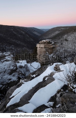 A beautiful pink and purple Belt of Venus gradient fills the horizon on a frigid sunrise at Lindy Point in Blackwater Falls State Park of Davis West Virginia.