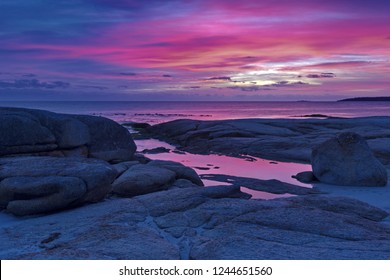 Beautiful pink and purple hues of sunrise at Cosy Corner South in Bay of Fires in Tasmania.