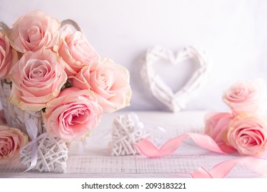 Beautiful pink roses in basket on vintage wooden table. Shabby chic style. Flower composition for holiday with copy space.
