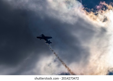 beautiful plane makes a difficult turn leaves a white trail of flight against the background of the sky