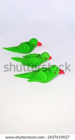 Beautiful plasticine clay green parrots isolated on white background. handmade birds.