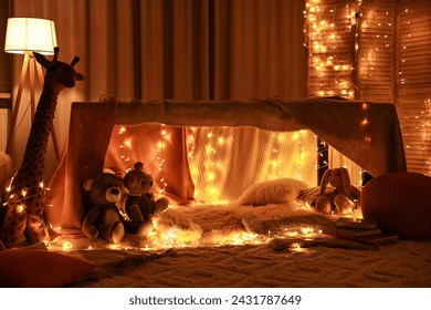 Beautiful play tent decorated with festive lights and toys at home - Powered by Shutterstock