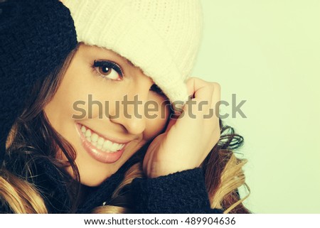 Beautiful playful woman pulling beanie over her eyes