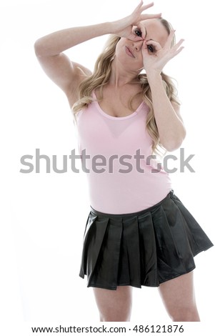 Beautiful Playful Young Caucasian Woman Looking Through Her Fingers in Fun Against A White Background