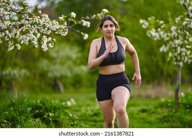 Beautiful Plus Size Runner Indian Woman Running On The Grass In The Orchard