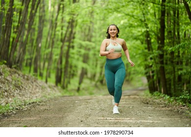 Beautiful Plus Size Runner Woman Running On A Dirt Road In The Forest