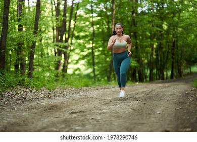 Beautiful Plus Size Runner Woman Running On A Dirt Road In The Forest