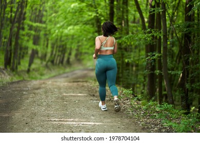 Beautiful Plus Size Runner Woman Running On A Dirt Road In The Forest