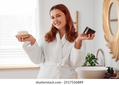 Beautiful plus size woman with anti-cellulite scrub and massage brush in bathroom - Powered by Shutterstock