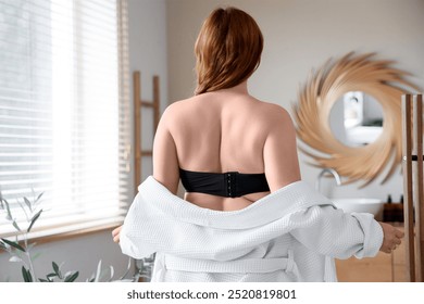 Beautiful plus size woman with bathrobe in bathroom, back view - Powered by Shutterstock