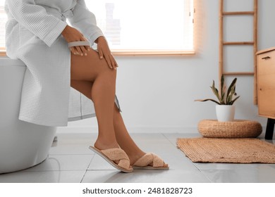 Beautiful plus size woman massaging her leg with anti-cellulite brush in bathroom - Powered by Shutterstock