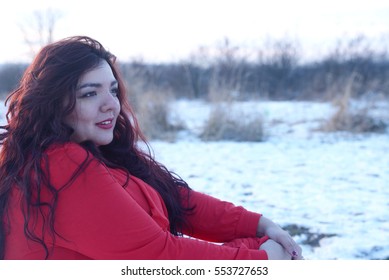 Beautiful plus size woman siting in the snow