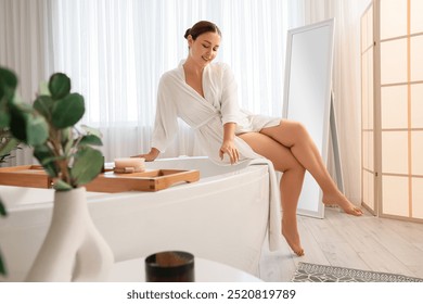 Beautiful plus size woman sitting on bathtub in bathroom - Powered by Shutterstock