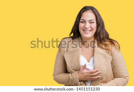 Beautiful plus size young woman wearing winter coat over isolated background Smiling and laughing hard out loud because funny crazy joke. Happy expression.
