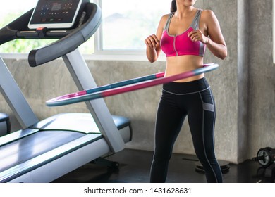 Beautiful portrait Asian woman doing hula hoop during an exercise class in gym - Powered by Shutterstock