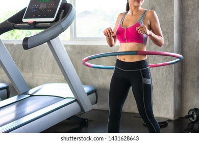 Beautiful portrait Asian woman doing hula hoop during an exercise class in gym - Powered by Shutterstock