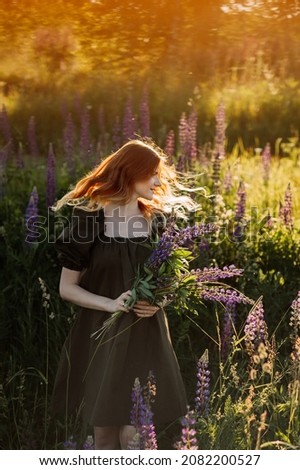 A beautiful portrait with the glare of the sun of a girl in a meadow.
